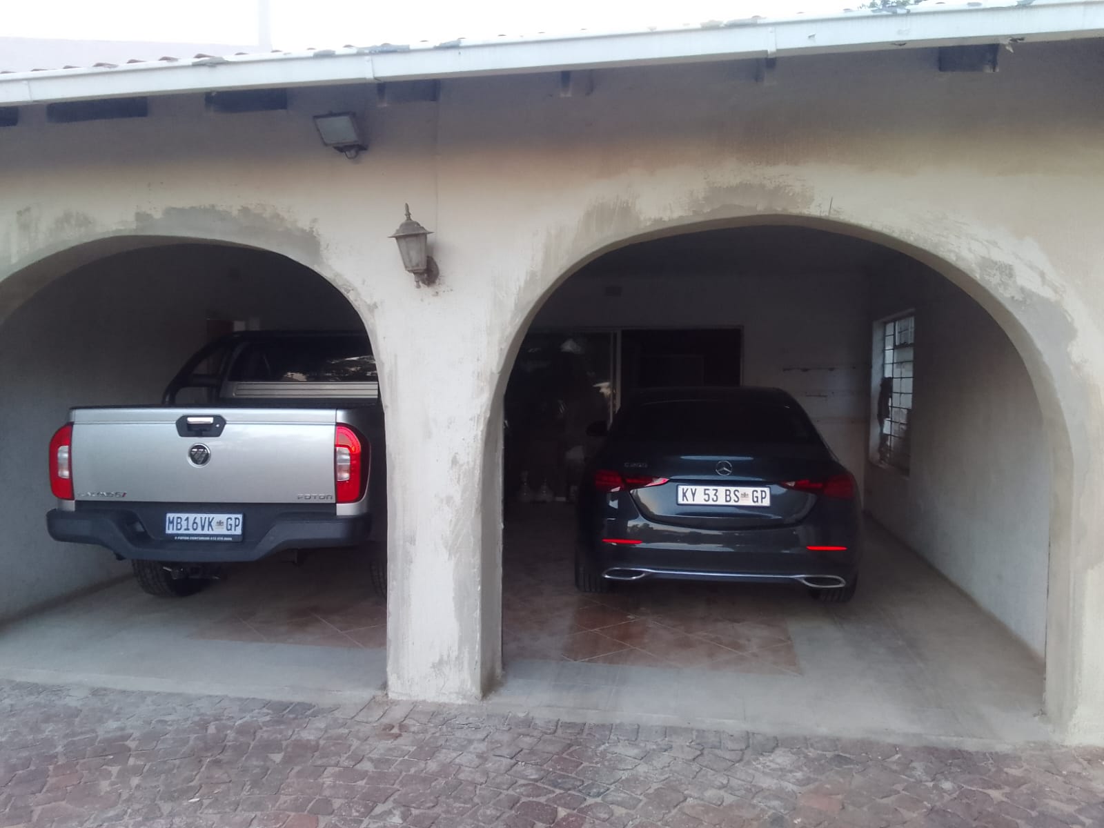 Double arched garages with vehicles parked